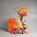 Artistic Floral Installation Design With Orange Fan Decorations Colorful Flowers And Fruit Ornaments