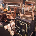 Vintage Daily Living Items Display With Cash Register Safe Cans Rolled Cloths And Furniture