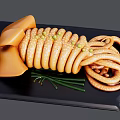 Sliced Cooked Squid Rings With Green Onions On Black Serving Plate