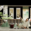 Traditional Chinese Setting With Man Holding Vessel Bonsai Scrolls Bamboo And Mountain Decorations