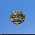 Intricate Carved Lion Head Ornament With Silver Texture Against Blue Sky