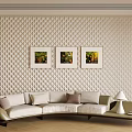 Light Colored Sectional Sofa With Cushions Against Beige Quilted Wall And Three Framed Landscape Paintings