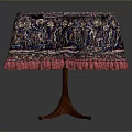 Round Dining Table With Red Blue Patterned Tablecloth And Pink Fringed Edges Wooden Legs