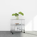 Metal Rolling Cart With Monstera Plant Magazines And Small Bowls
