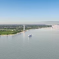 Grand Modern Suspension Bridge Spanning Wide River With Cruise Ships And Lush Riverside Landscape