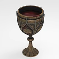 Ornate Metallic Wine Glass Featuring Carved Geometric Floral Patterns Flared Base And Red Wine Inside