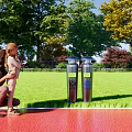 Outdoor Trash Bins With Green Grass Trees And Adult Child Nearby