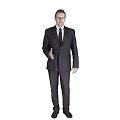 A Man In Dark Suit Standing Against Gray Background With Right Hand Extended For Greeting