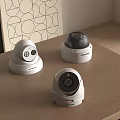 Three Different Surveillance Camera Models Placed On Wooden Table For Security