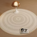 Round Rug With Concentric Circle Design Mushroom Lamp Open Photo Book On Neutral Beige Floor