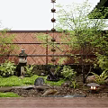 Relaxing Japanese Courtyard Garden with Bamboo Fence Stone Lantern Lush Plants Rocks and Wooden Deck