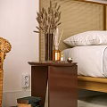 Modern Brown Side Table by Bed with White Pillow and Dried Plant Vase
