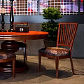 Round Wooden Dining Table With Upholstered Chairs And Decorative Candle Holders