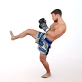 Man Performing High Kick In Boxing Gloves And Sports Shorts During Training