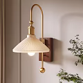Modern Wall Lamp with White Pleated Lampshade Gold Arm Wooden Base and Plant Near Wall