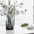 Green Glass Vase With Fresh White Flowers And Green Branches On White Tabletop