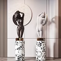 Black And White Nude Female Sculptures With Marble Pedestals And Circular Decorative Wall Background