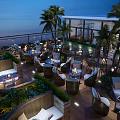 Chic Rooftop Bar With Outdoor Seating Palm Trees Candlelit Tables And Ocean Night View