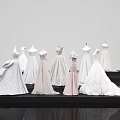 Elegant White And Pink Formal Dresses On Mannequins With Long Flowy Skirts