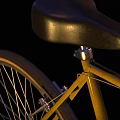 Modern Yellow Bicycle With Black Seat Handlebar And Orange Rimmed Wheels