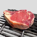 Fresh Ribeye Beef Steak On Black Grill With Juicy Red Meat And Fat