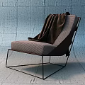 Modern Leisure Chair with Woven Fabric Black Metal Frame and Brown Blanket Against Concrete Wall