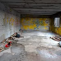 Abandoned Room Featuring Brick Walls Yellow Graffiti Broken Windows Damaged Ceiling And Floor Debris