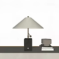 Modern Table Lamp With White Shade And Black Base On Table With Books And Bowl