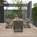 Outdoor Patio Rattan Dining Table And Chairs With Striped Cushions Surrounded By Green Plants