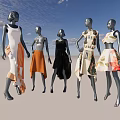 Fashion Mannequins Displaying Various Stylish Dresses Against Blue Sky With White Clouds