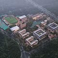 Aerial View of Modern School Buildings with Green Surroundings Sports Field and Lake