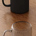 Black Ceramic Mug And Clear Glass Cup On Wooden Table