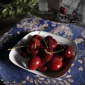 Deep red cherries in white plate on blue patterned cloth 3d model