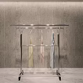 Sturdy Metal Rolling Clothes Rack With Hanging Garments Against Grey Wall