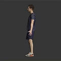 Man in V neck T shirt and shorts standing with sneakers on dark background