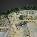 Open Pit Mine Terrain With Terraced Excavated Layers And Green Vegetation