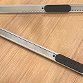 Stainless Steel Utility Knives With Serrated Blades And Black Handles On Wooden Table