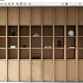 Light Wood Bookcase With Multiple Open Shelves Holding Decorative Vases And Books
