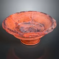 Red Bowl Shaped Sculpture With Irregular Edges And Textured Surface On Base