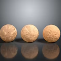 Three Spherical Stone Objects With Rough Texture On Light Brown Wood Surface And Reflections