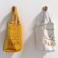 Yellow and White Tote Bags with Bear Design and BEAR Lettering Hanging on Wall