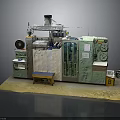 Industrial Processing Equipment With Green White Casing Control Knobs Pipes Yellow Stool And Platform