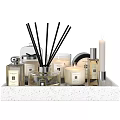 Elegant Decorative Ornament Set Featuring Reed Diffusers Candles And Fragrance Bottles On Textured Tray