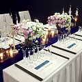 Elegant Dining Table Setup With Floral Bouquets Candles Wine Glasses And Menu Cards