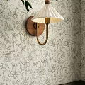 Elegant Wall Lamp With White Pleated Shade And Wooden Base On Floral Wallpaper
