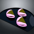 Three Pink Shell Green Filling Snacks on Black Fan Shaped Plate