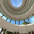 Circular Tower With Multiple Wooden Rings Open Sky View Supporting Pillars And Green Trees