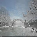 Stone Arch Bridge With Snow Covered Trees Frozen River Sunlight And Blue Sky