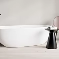 White Freestanding Bathtub With Black Faucet Pink Chair And Wooden Floor In Light Bathroom