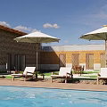 Stone And Wooden Boutique Villa Exterior With Swimming Pool Lounge Chairs And Umbrella